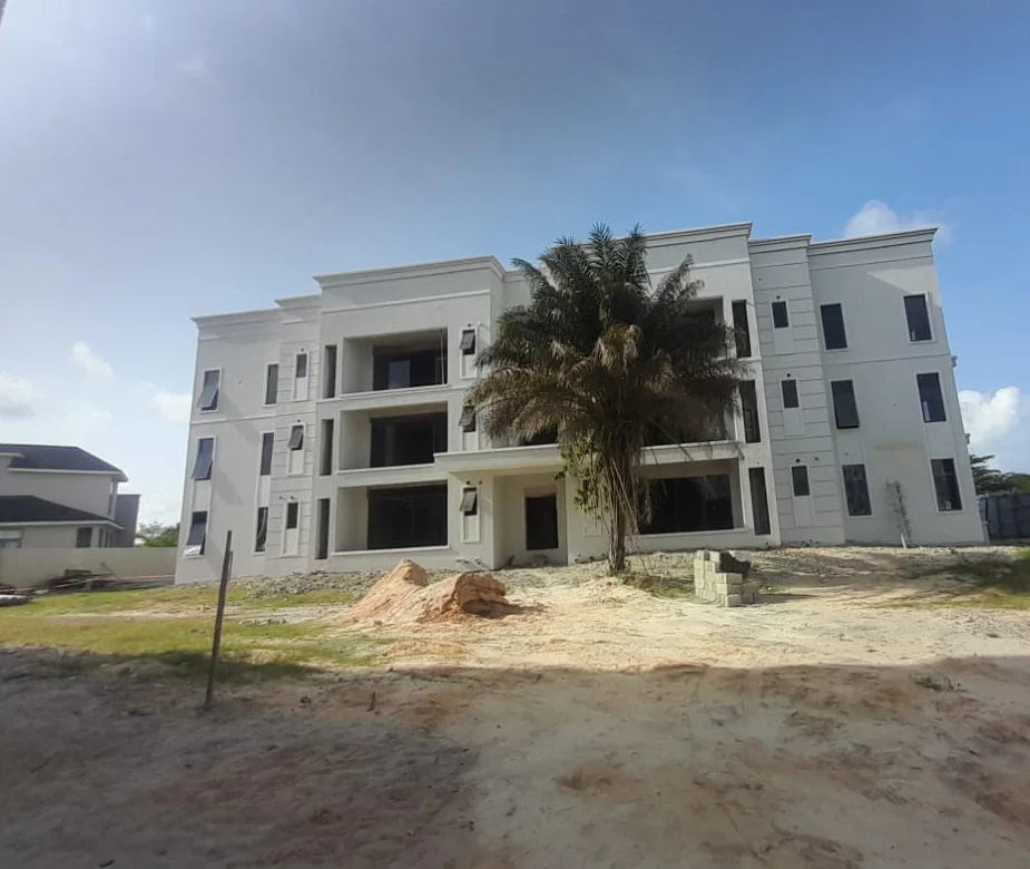 Residential construction site with a multi-storey building and palm trees